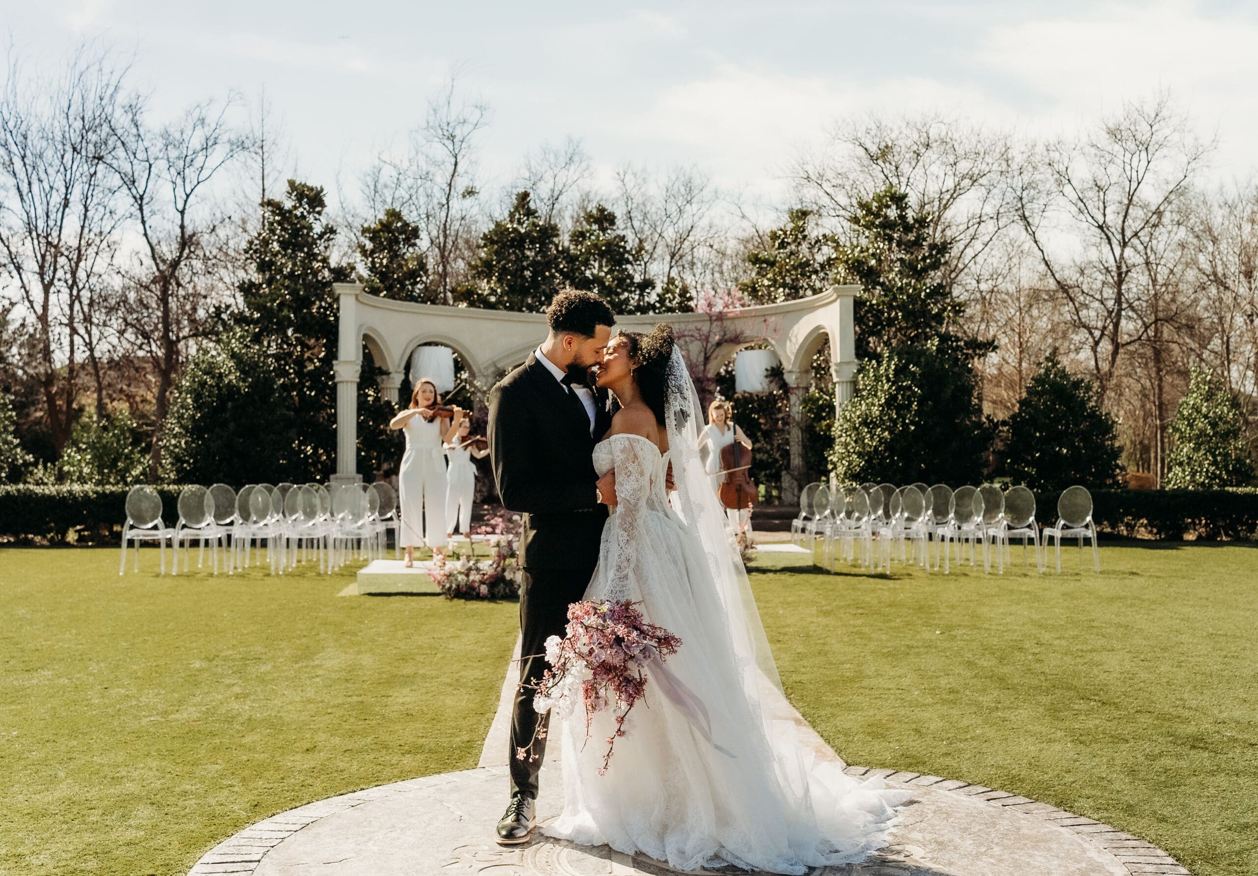 Bride and groom on a lawn before an outdoor ceremony