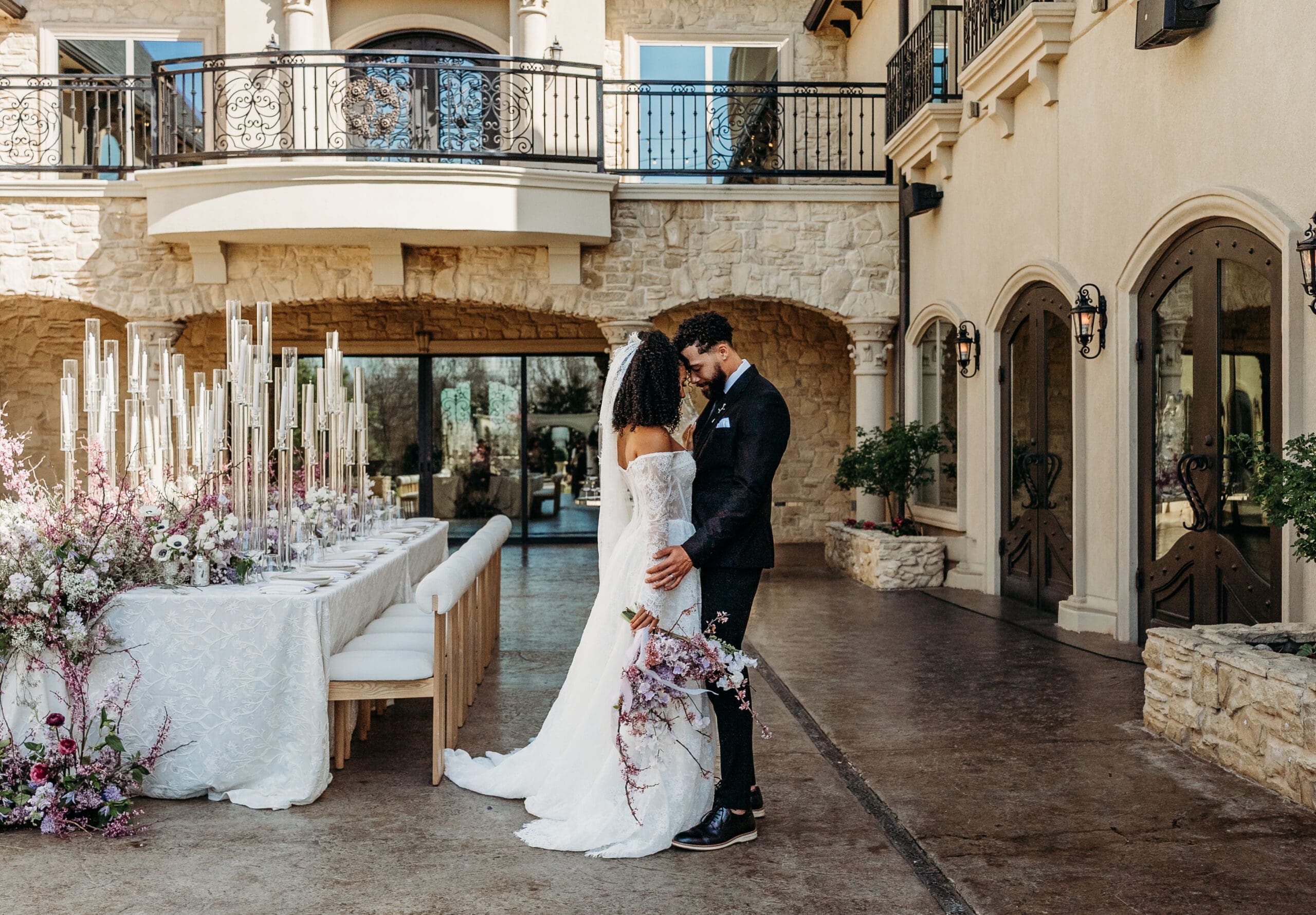 Bride and groom exchanging vows at a stone-arched ceremony