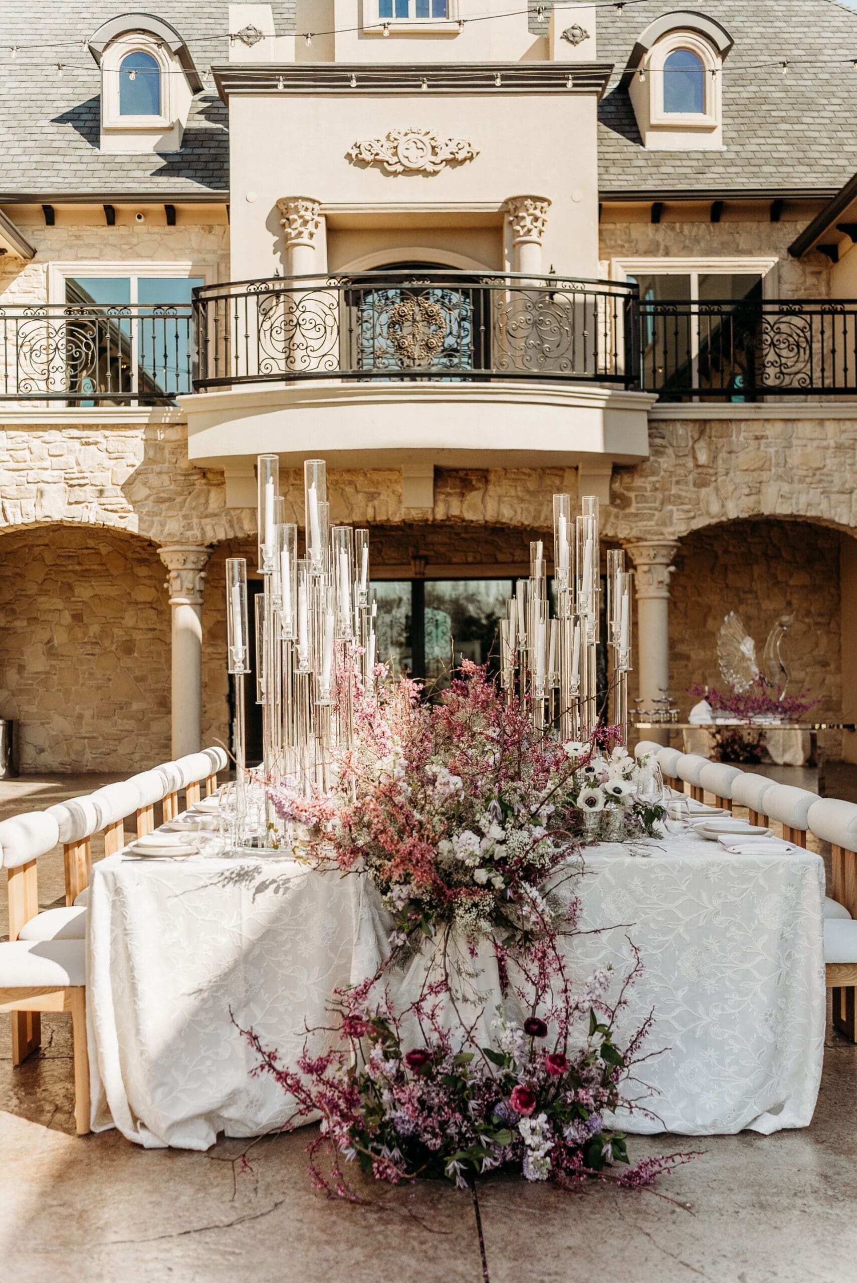 Elegant courtyard venue decorated with dramatic florals and candles