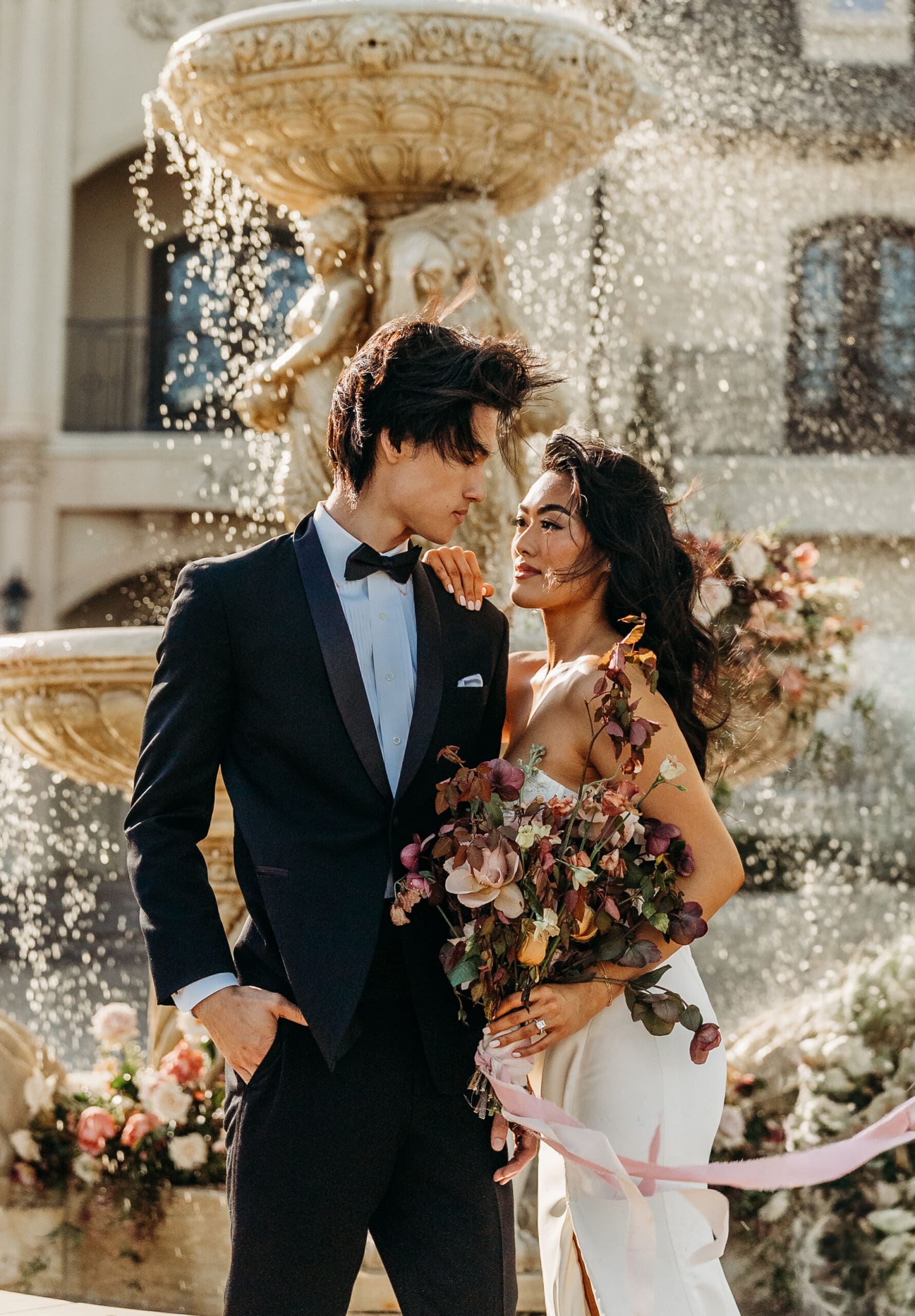 Couple sharing an intimate moment beneath a golden chandelier