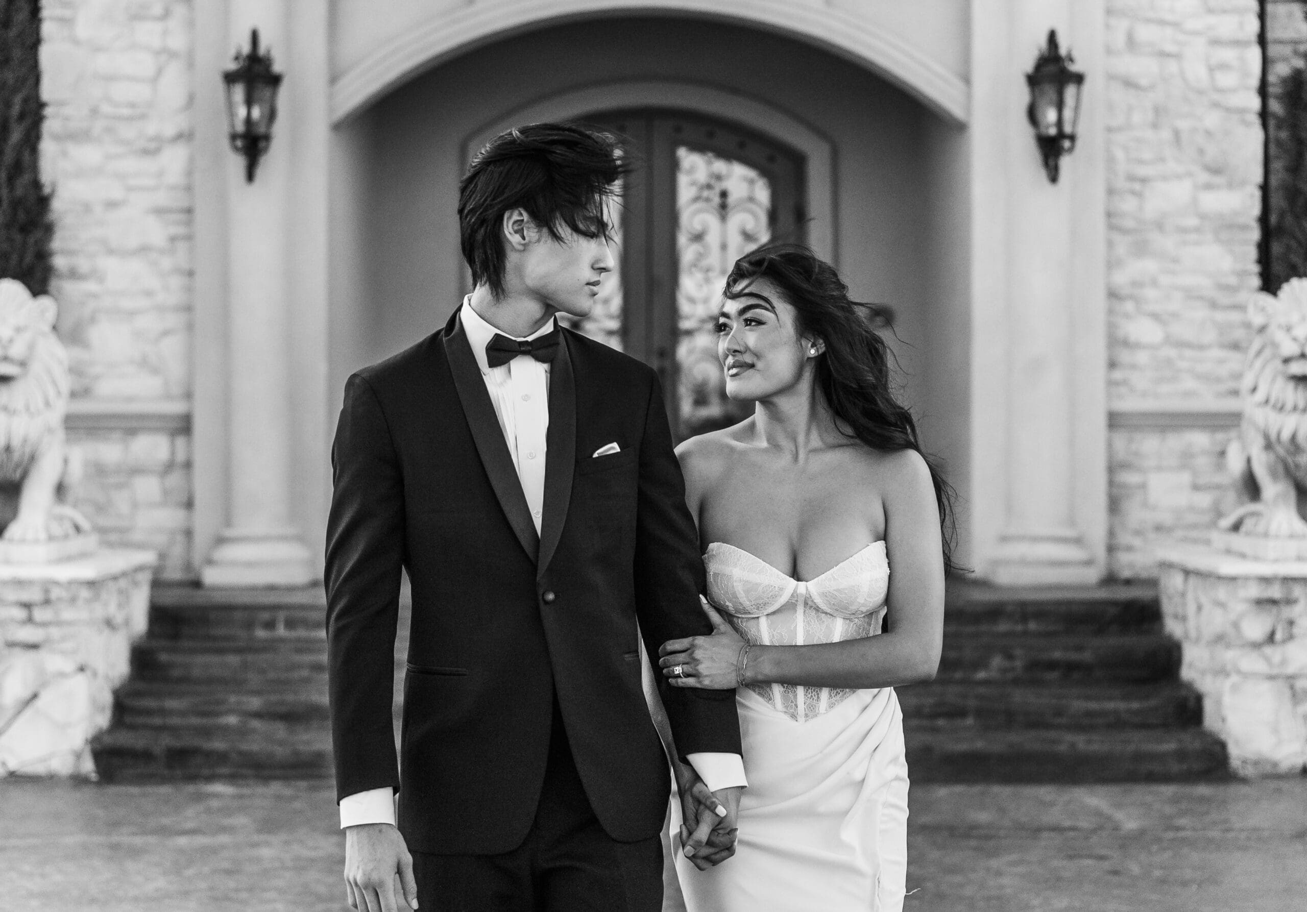 Formally dressed couple laughing together outside a columned building