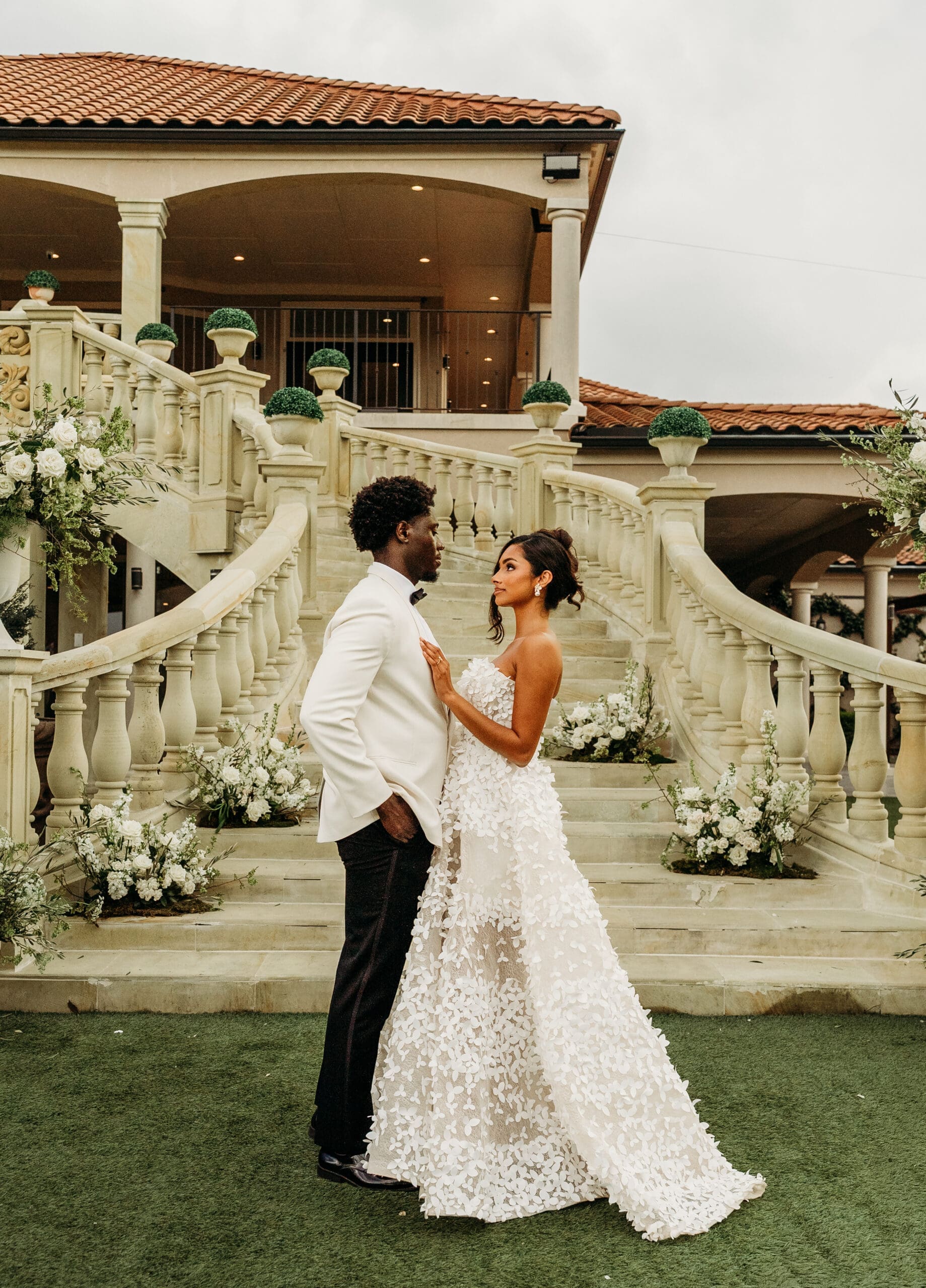 Bride and groom share a romantic moment on a venue lawn