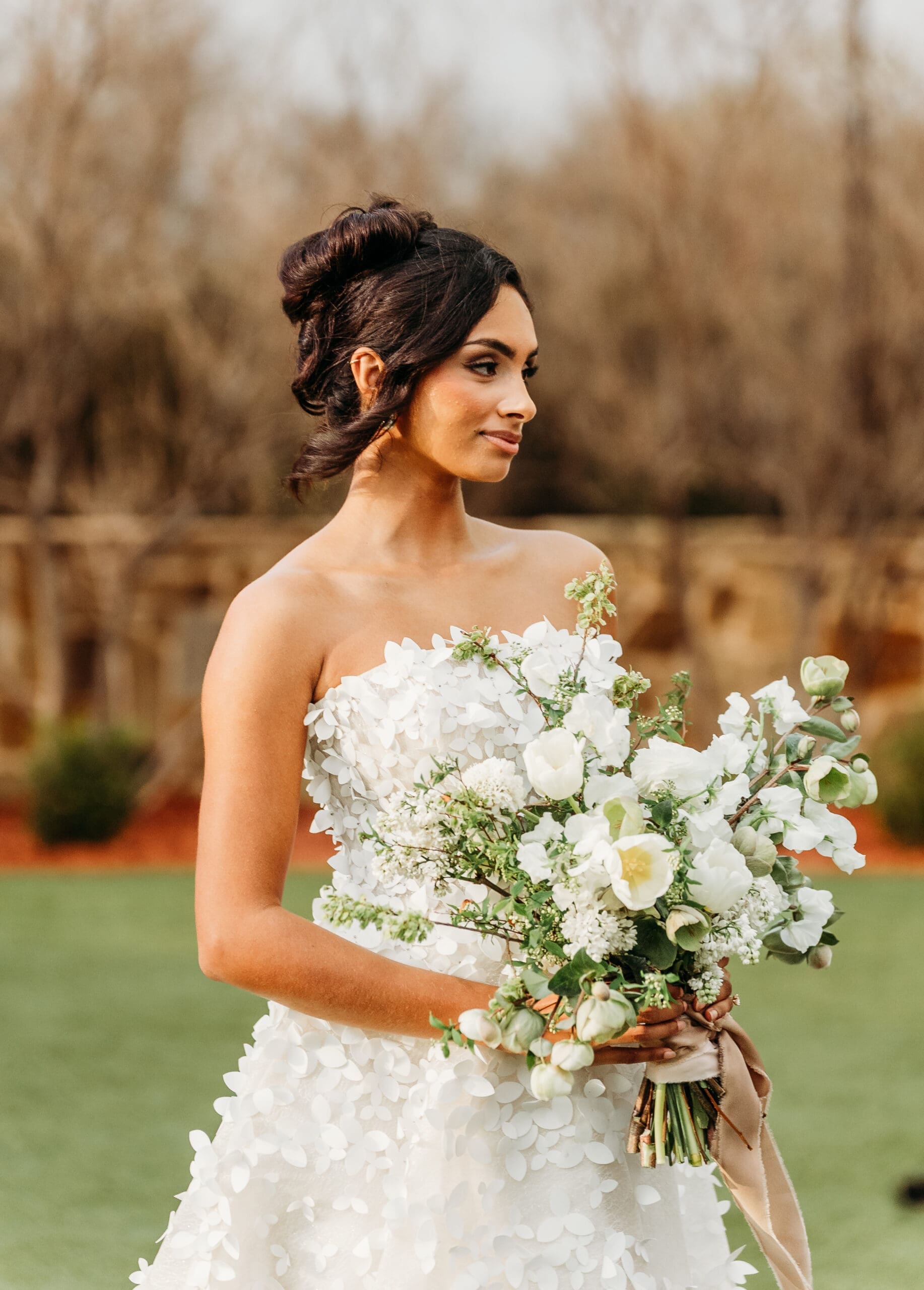 Bride in a white wedding dress holding a white floral bouquet