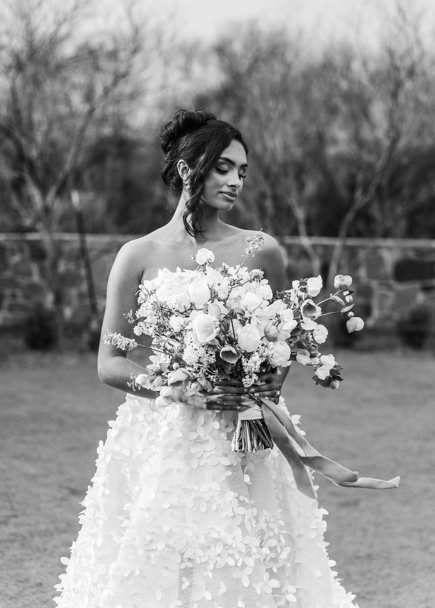 Bride in white lace dress holding a large white floral bouquet