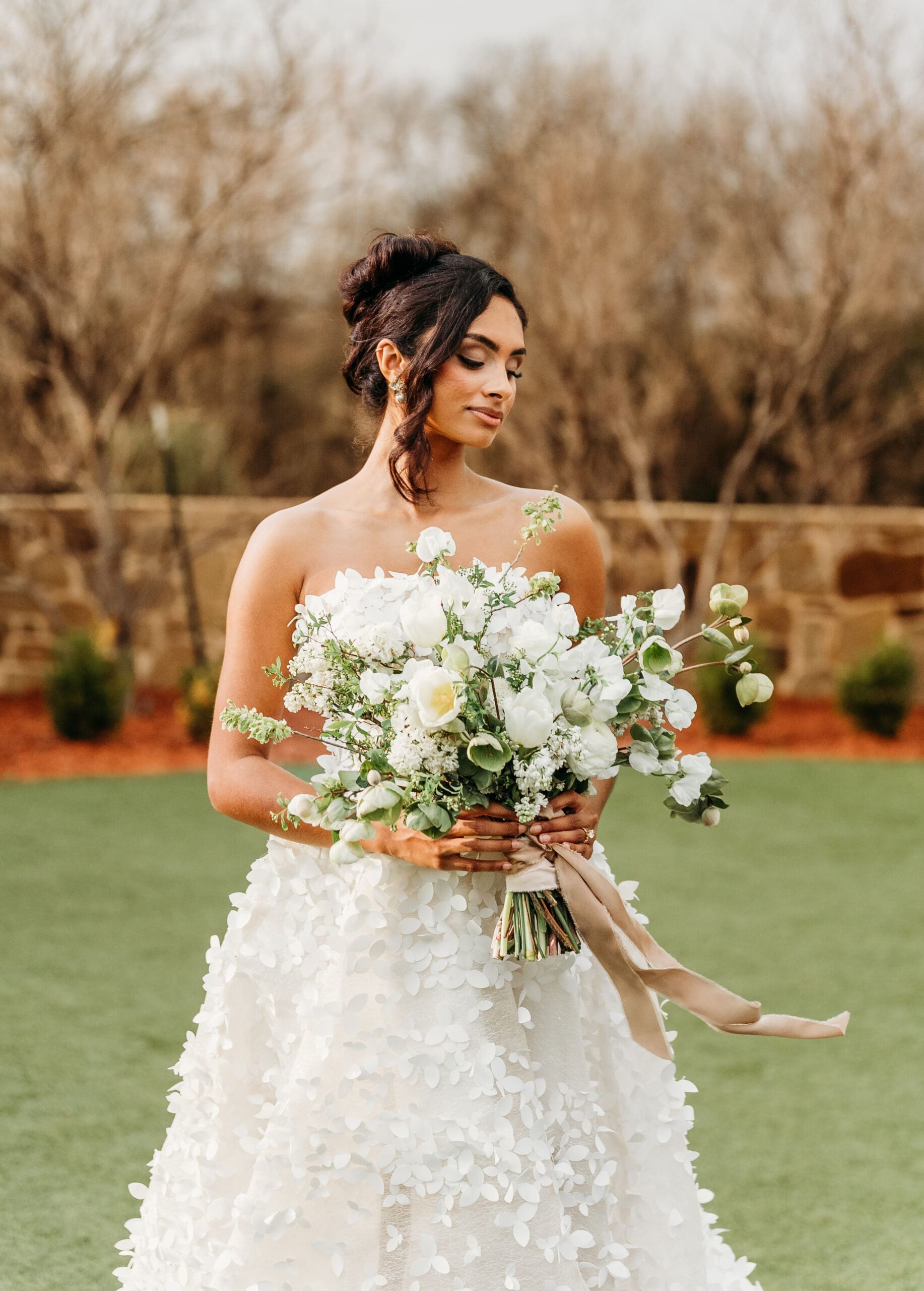 Bride in white lace dress holding a white floral bouquet