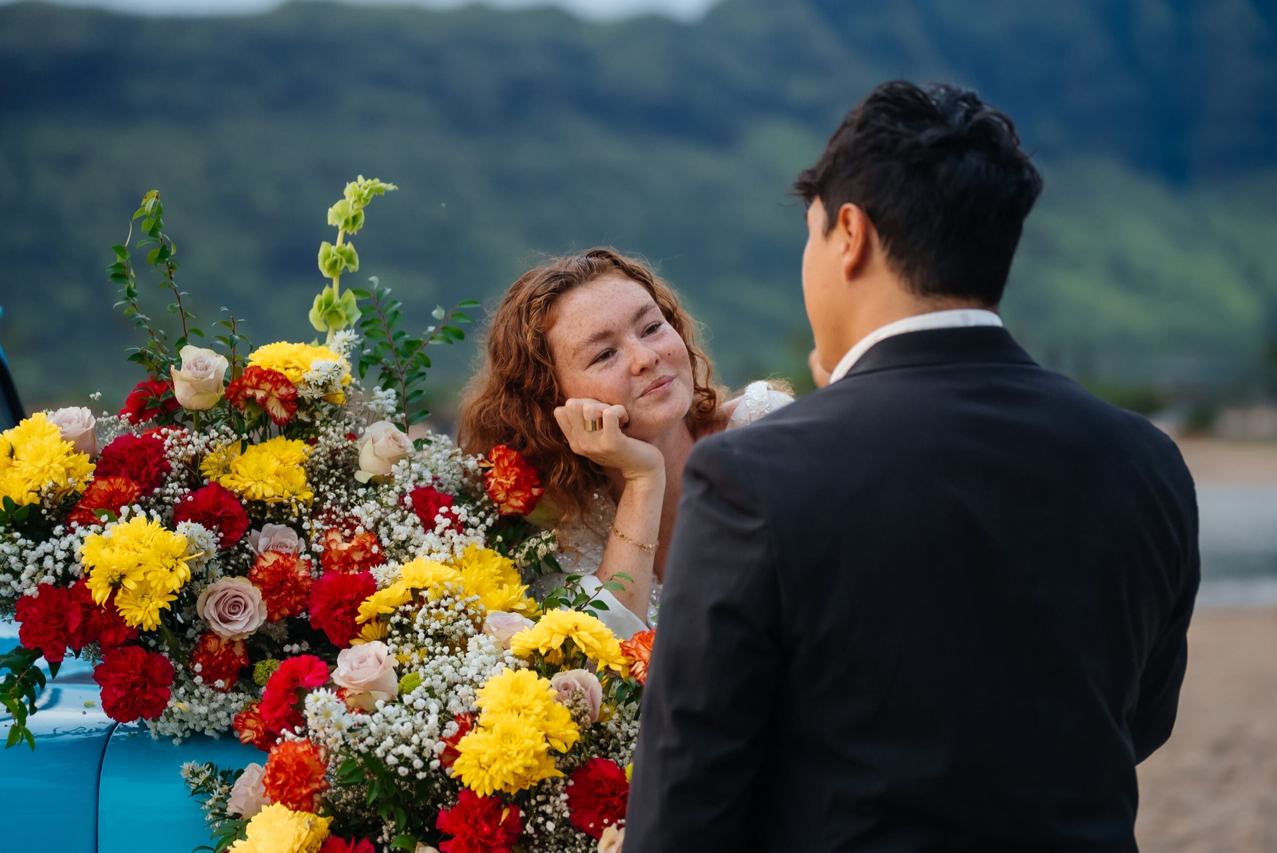 Couple at an outdoor wedding ceremony with colorful flowers